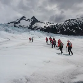 a group of people riding skis down a snow covered mountain