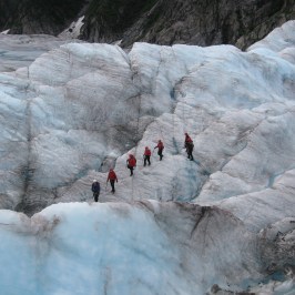 a group of people walking across a snow covered mountain
