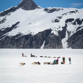 a group of people standing on top of a snow covered mountain