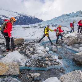 a group of people standing on a rock in the snow