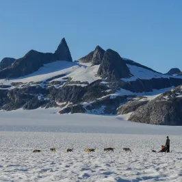 a group of people walking across a snow covered mountain