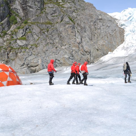 a group of people riding skis down a snow covered mountain