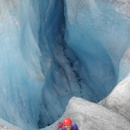a man riding a skateboard up the side of a snow covered mountain