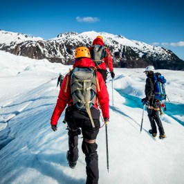 a group of people walking across a snow covered mountain
