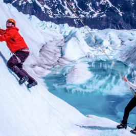 a man riding skis down a snow covered mountain