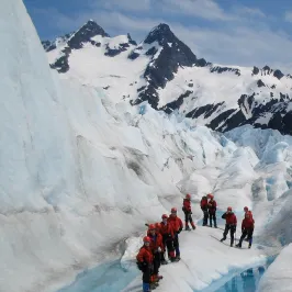 a group of people standing on top of a snow covered mountain