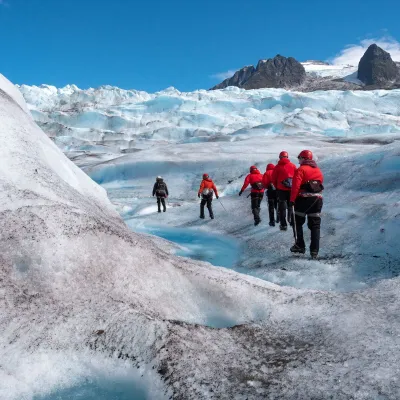a group of people walking across a snow covered mountain