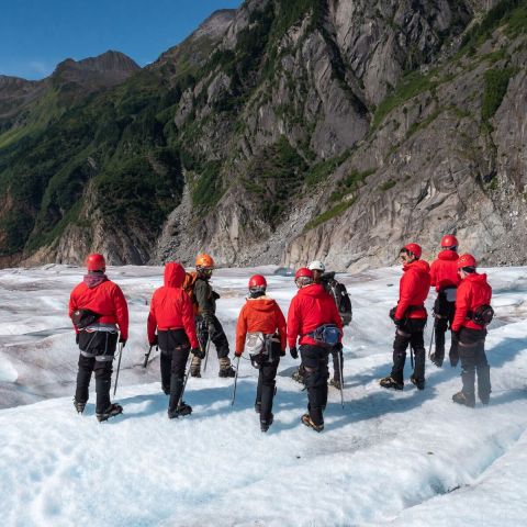 a group of people standing on top of a snow covered mountain