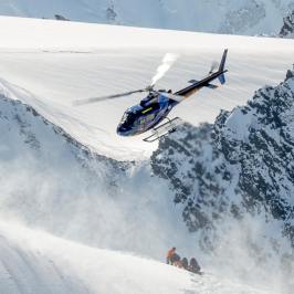 helicopter and people on snow covered mountains