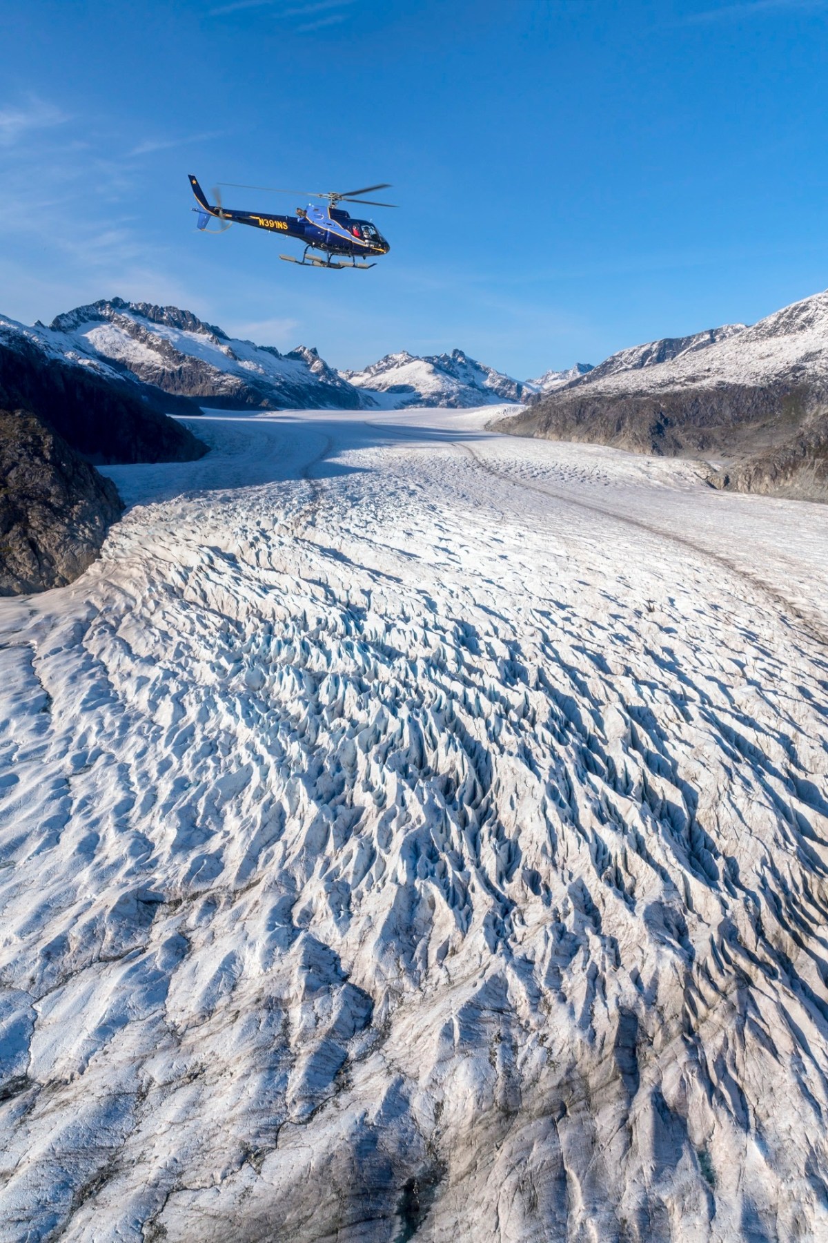 Helicopter Flightseeing and Glacier Landing Tour Image 2 a person flying through the air on a snow covered mountain